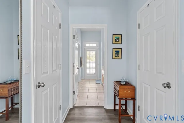 a view of a hallway with wooden floor and a bathroom