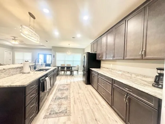 a large kitchen with stainless steel appliances kitchen island granite countertop a sink and cabinets