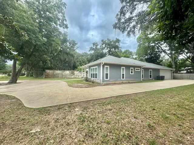 a front view of house with yard and trees in the background