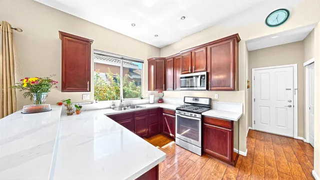 a kitchen with stainless steel appliances granite countertop a stove a sink and a refrigerator