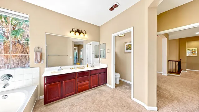 a bathroom with a tub sink and mirror