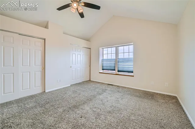 an empty room with fan and windows