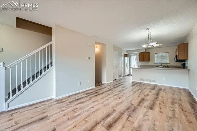 a view of an empty room with a fireplace and a window