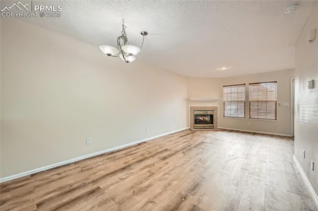 an empty room with windows and fireplace