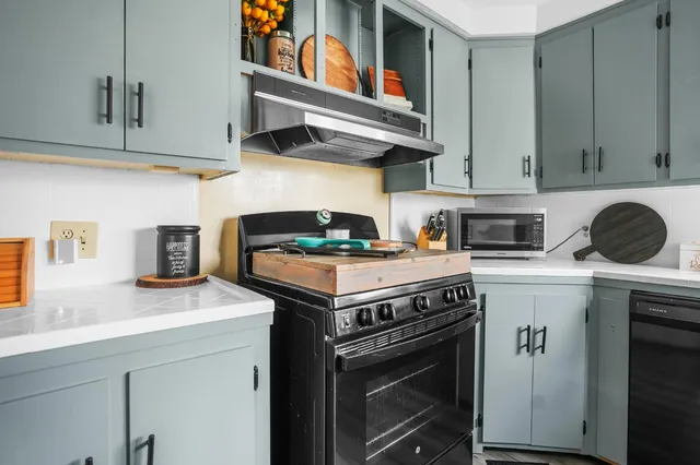 a kitchen with stainless steel appliances granite countertop a stove a sink and a microwave