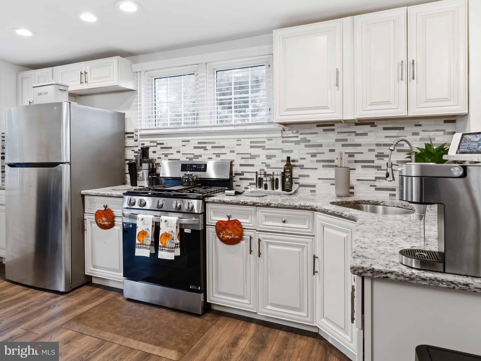 1008 Springfield Road Collingdale, PA 19023 - Photo 18 of 48 a kitchen with stainless steel appliances granite countertop a refrigerator a stove a sink and white cabinets
