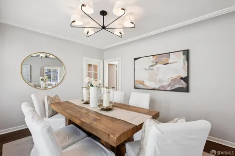 a dining room with wooden floor a glass table and chairs