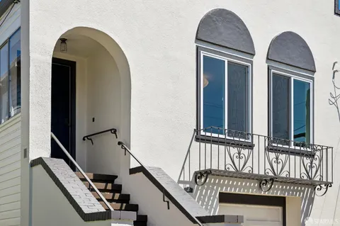 a view of staircase with railing and a chandelier