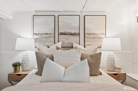 a living room with furniture and a painting on the wall