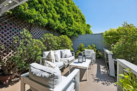 a view of a patio with couches table and chairs and potted plants