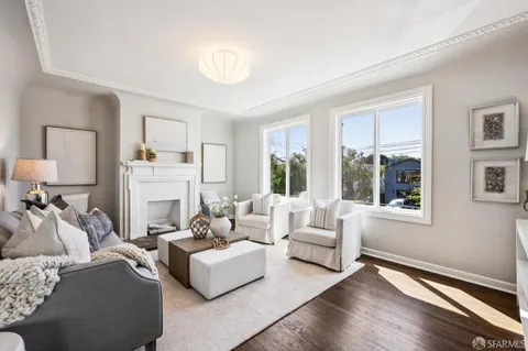 a living room with furniture fireplace and a large window
