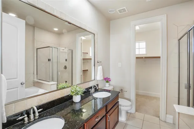 a bathroom with a granite countertop tub sink and mirror