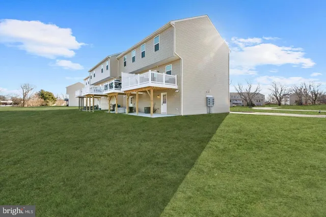 a view of a house with a big yard and large trees
