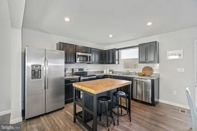 a kitchen with stainless steel appliances granite countertop a stove refrigerator sink and microwave