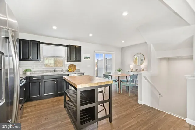 a large kitchen with kitchen island a sink table and chairs