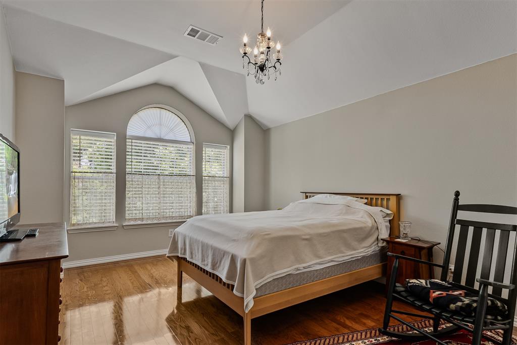 9301 Nottingham Court Rowlett, TX 75088 - Photo 31 of 39 Vaulted ceiling room featuring wood-finish flooring, a decorative chandelier, and an arched window with two rectangular windows below