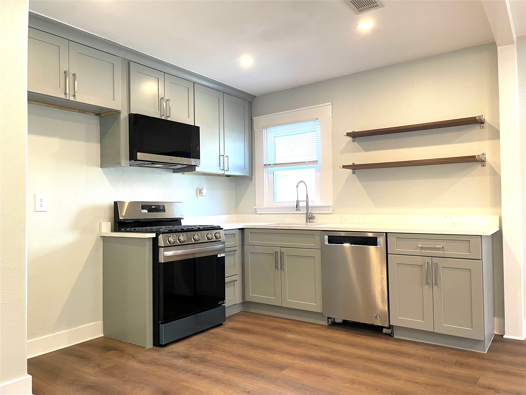 807 East Riverside Drive, Unit A Austin, TX 78704 - Photo 9 of 29 Kitchen with gray cabinetry, stainless steel appliances, open shelves, and recessed lighting