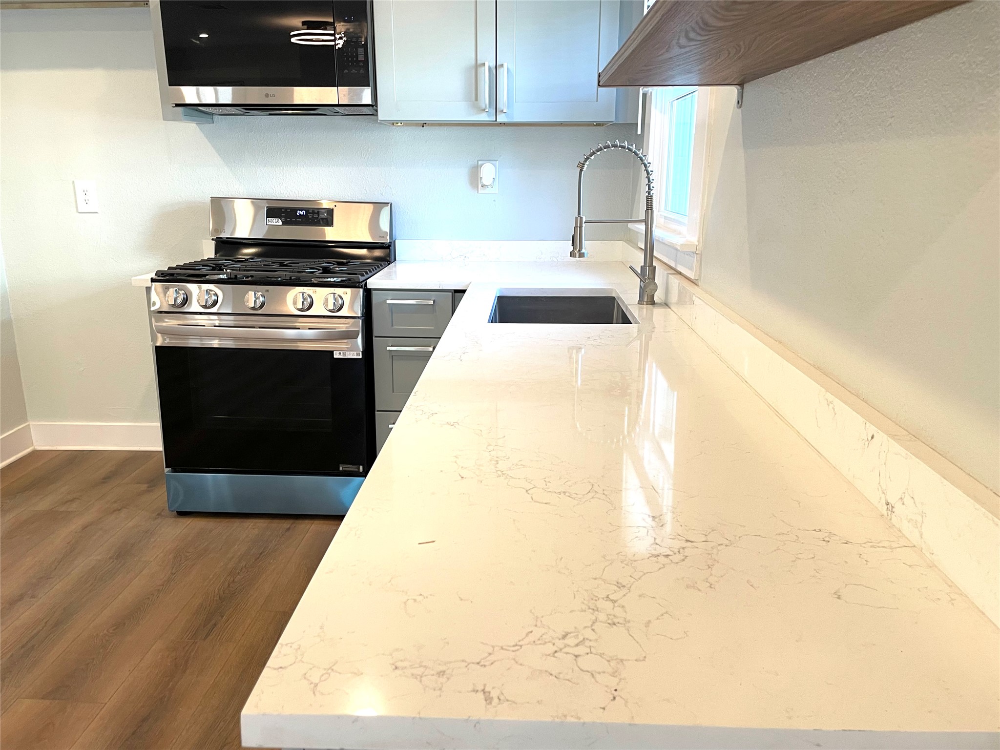 807 East Riverside Drive, Unit A Austin, TX 78704 - Photo 10 of 29 Kitchen with stainless steel appliances, light stone counters, and dark wood-style flooring