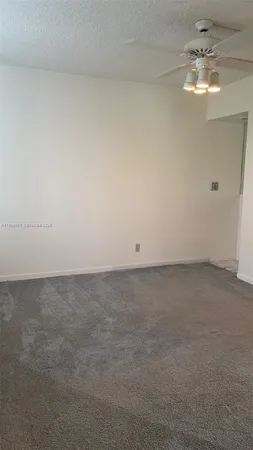 an empty room with windows and chandelier