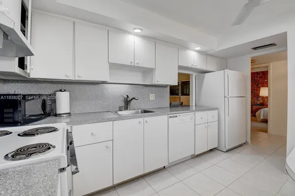 a kitchen with granite countertop cabinets and refrigerator