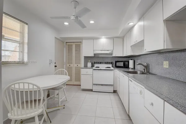 a kitchen with a sink window and cabinets