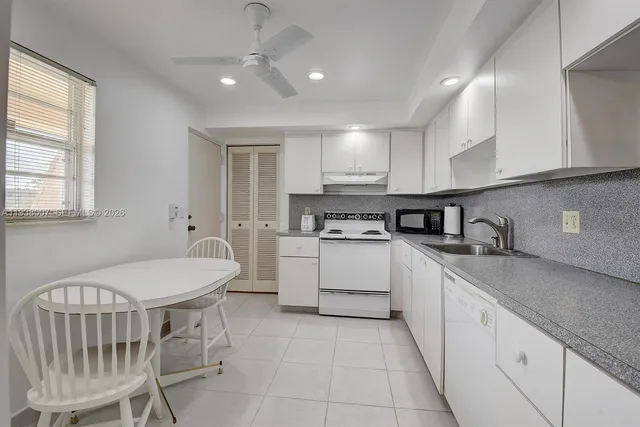 a kitchen with a sink window and cabinets