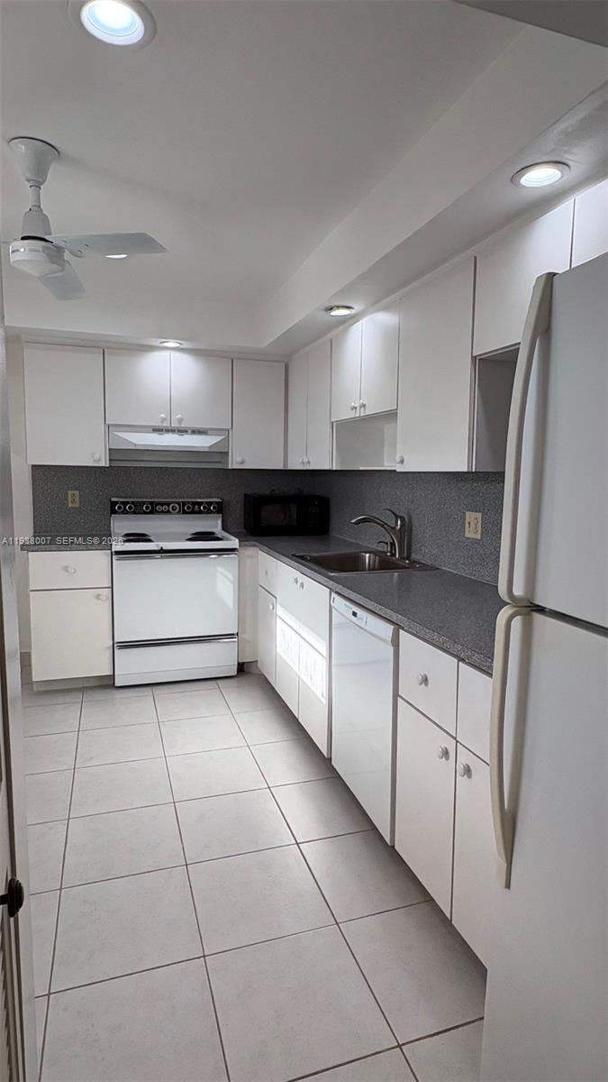 6300 Northwest 2nd Avenue, Unit 403 Boca Raton, FL 33487 - Photo 6 of 20 a kitchen with granite countertop a refrigerator sink and cabinets