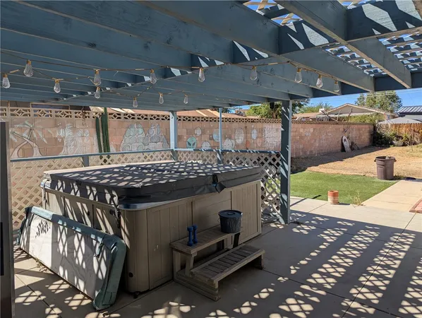 a view of a patio with table and chairs under an umbrella