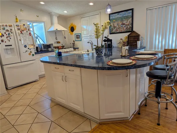 a kitchen with stainless steel appliances a sink a stove a refrigerator and cabinets