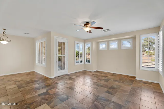 a view of empty room with wooden floor and windows