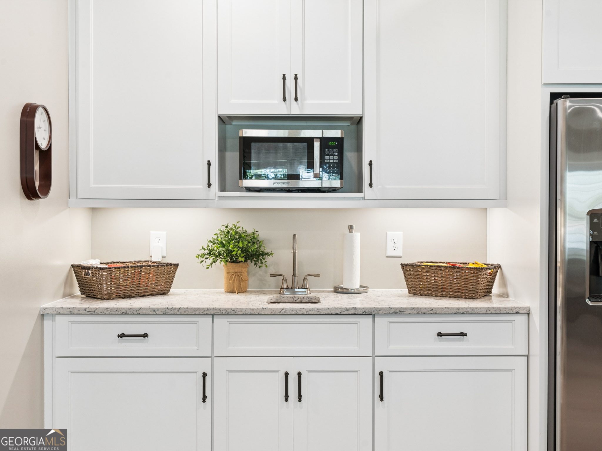 143 Carlota Way Hartwell, GA 30643 - Photo 23 of 48 a kitchen with a potted plant on the counter and cabinets