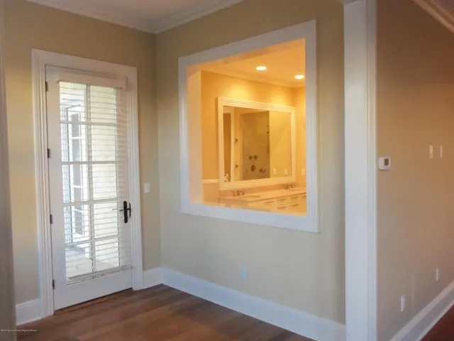 an empty room with wooden floor and windows with curtains