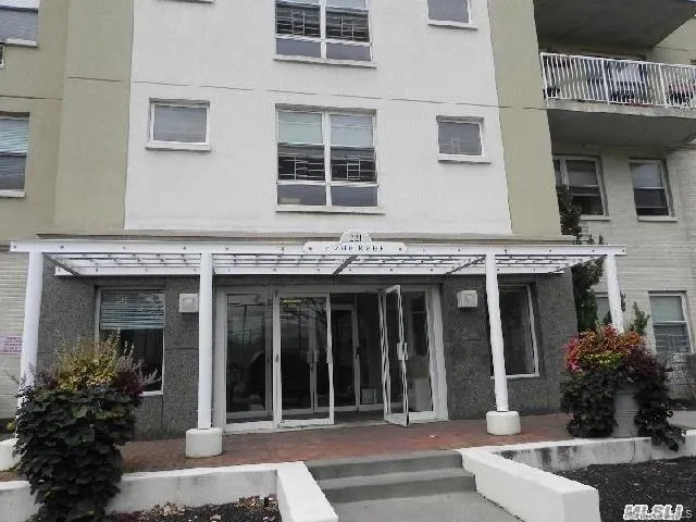 a view of a brick building with potted plants and a table and chairs