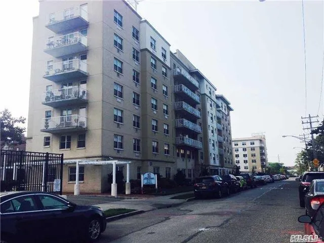 a view of a building and car parked on the roadside