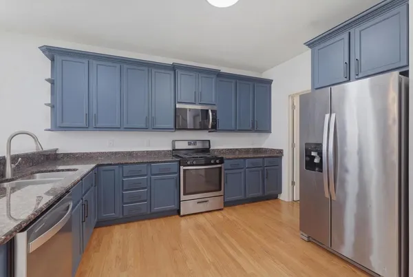 a kitchen with stainless steel appliances granite countertop a refrigerator stove and sink