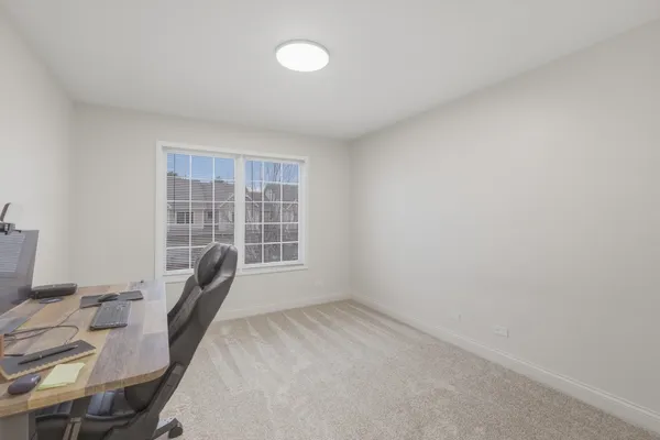 a view of a workspace with furniture and a window