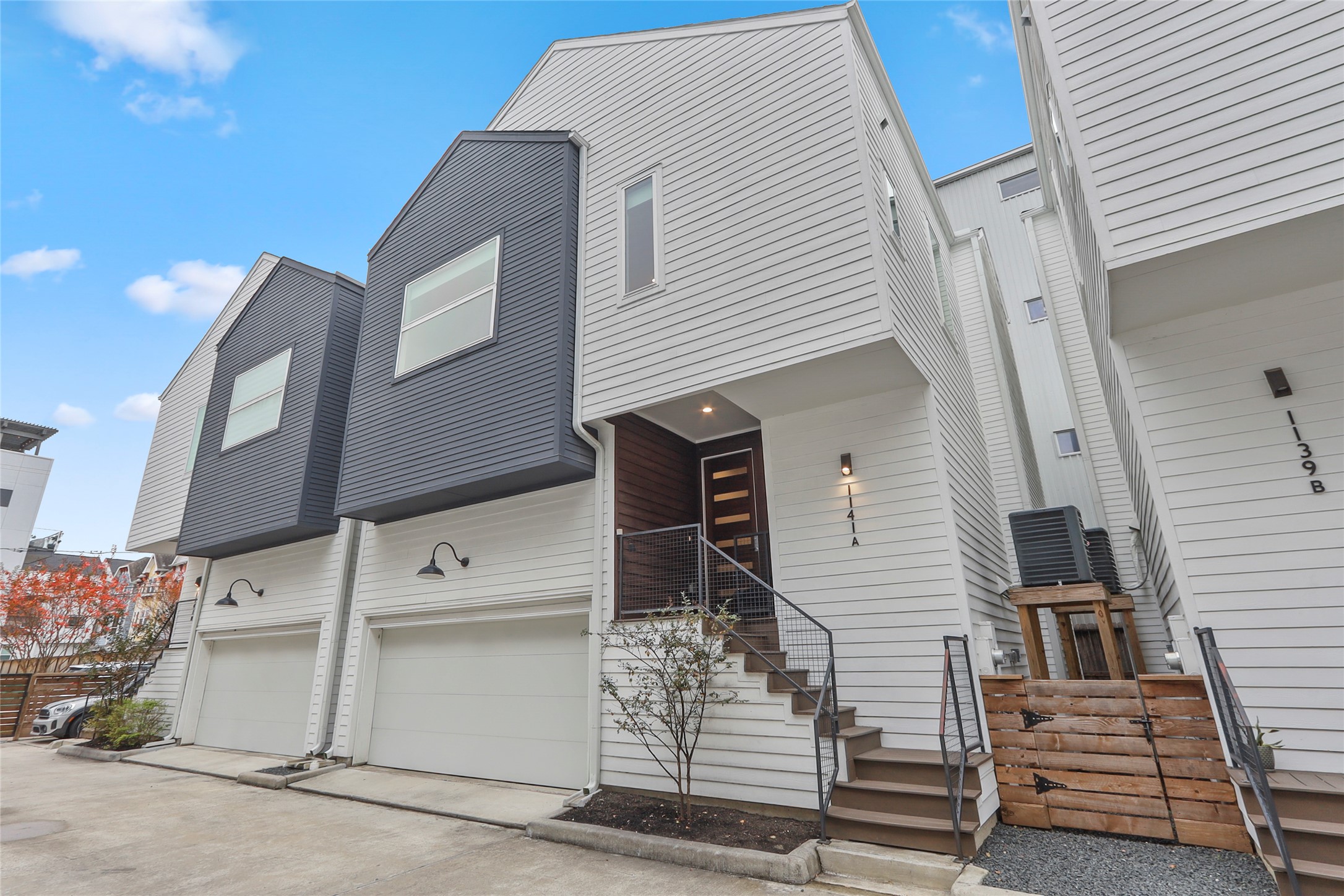 Modern home with stairs, a garage, and shared driveway