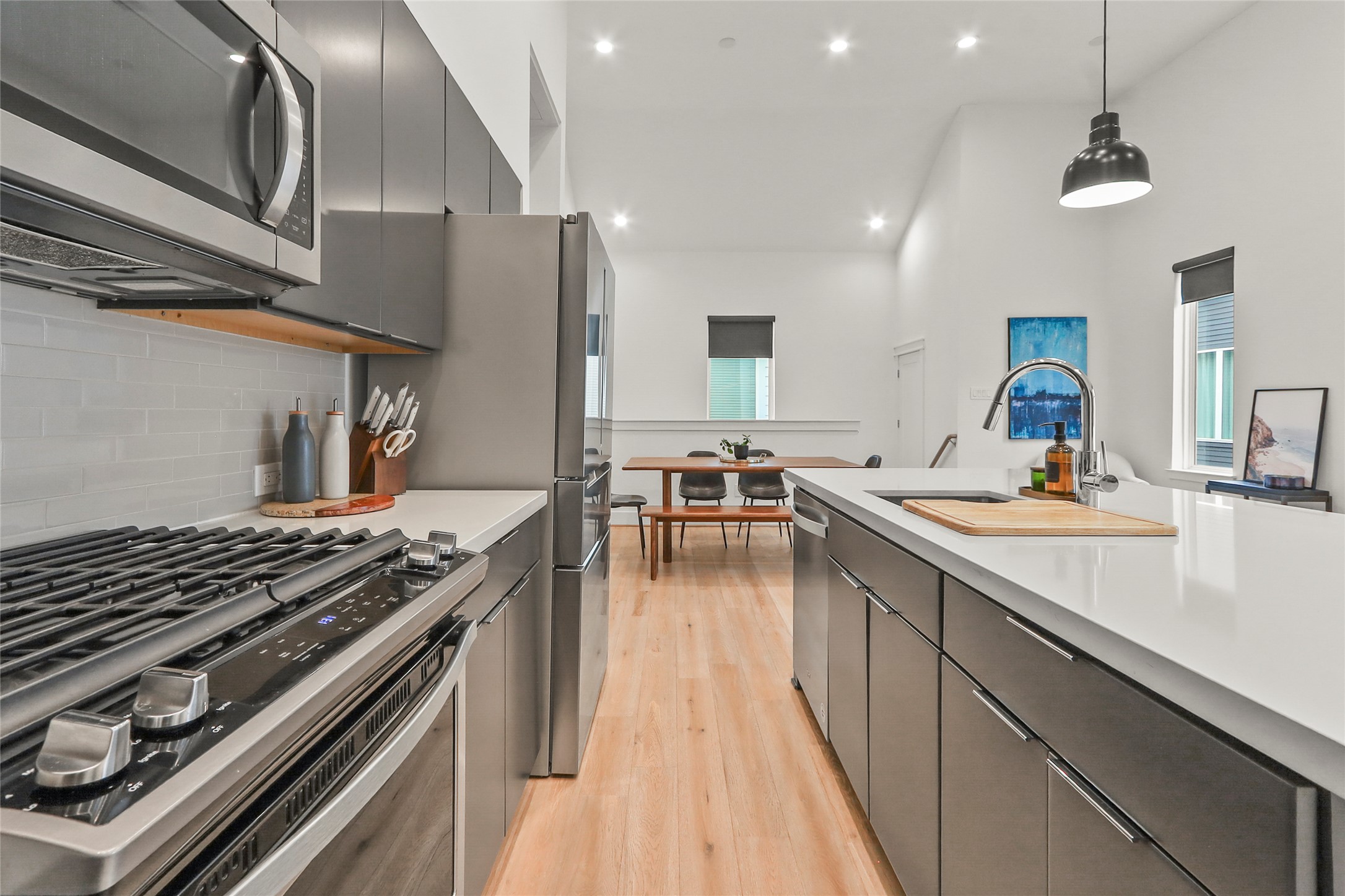 1141 West 17th Street, Unit A Houston, TX 77008 - Photo 7 of 18 Kitchen with appliances with stainless steel finishes, pendant lighting, light countertops, light wood finished floors, and recessed lighting