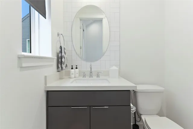 a bathroom with a sink toilet and mirror