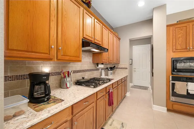 a kitchen with stainless steel appliances granite countertop a sink stove and cabinets