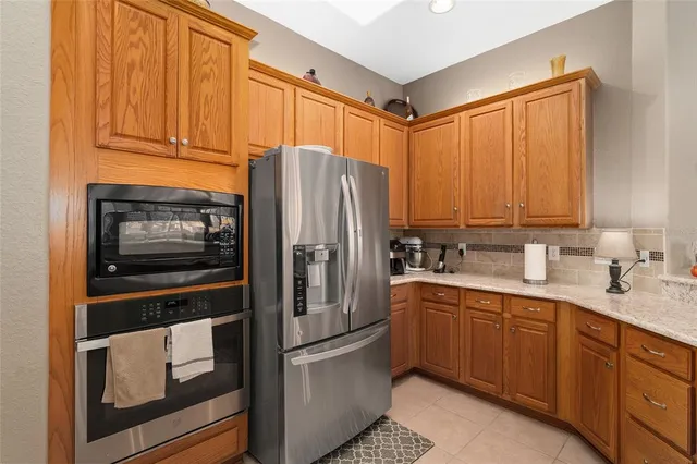 a kitchen with stainless steel appliances granite countertop a refrigerator and a stove top oven