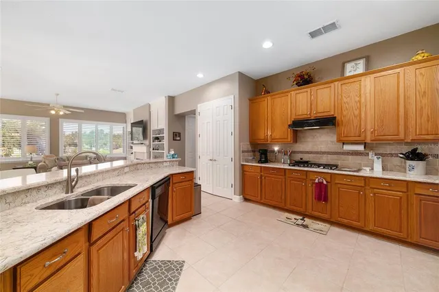 a large kitchen with stainless steel appliances granite countertop a sink and cabinets
