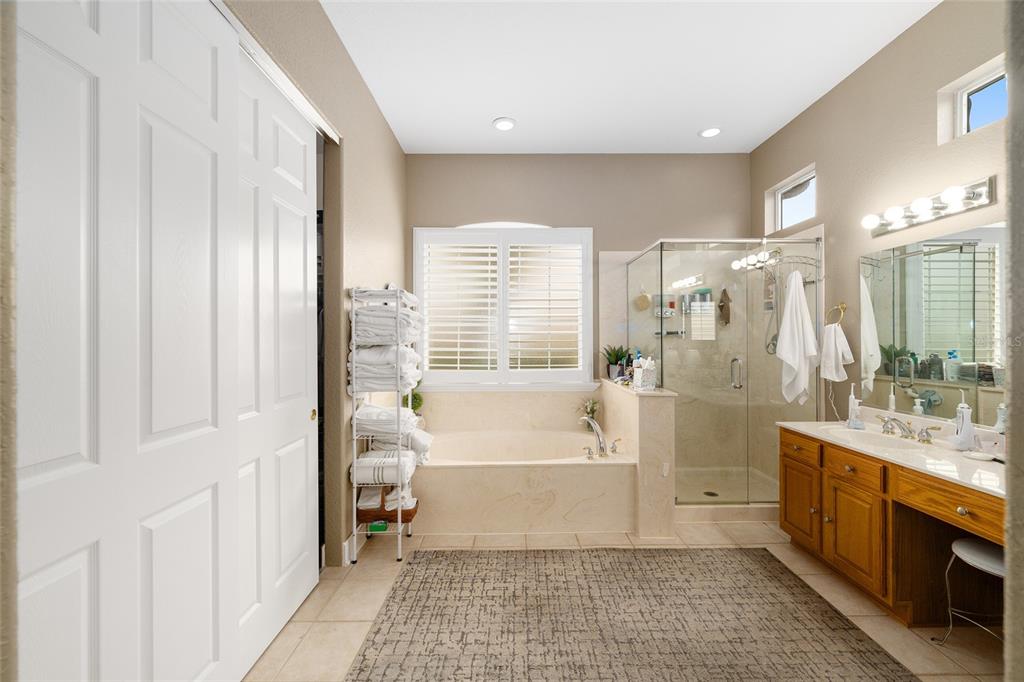 9479 Southeast 130th Street Road Summerfield, FL 34491 - Photo 24 of 67 a bathroom with a tub a sink and a large mirror