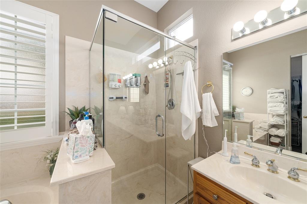 9479 Southeast 130th Street Road Summerfield, FL 34491 - Photo 26 of 67 a bathroom with a sink mirror and a shower