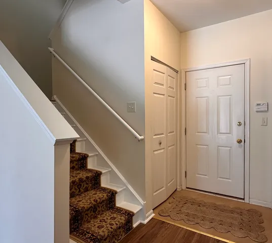 a view of entryway with wooden floor and stairs