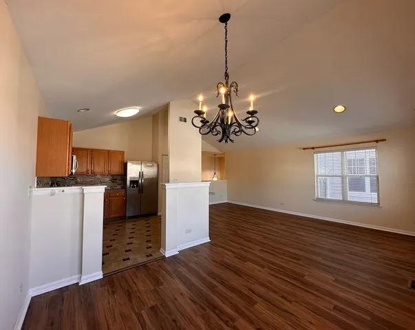 a view of a kitchen with a sink wooden floor and a chandelier