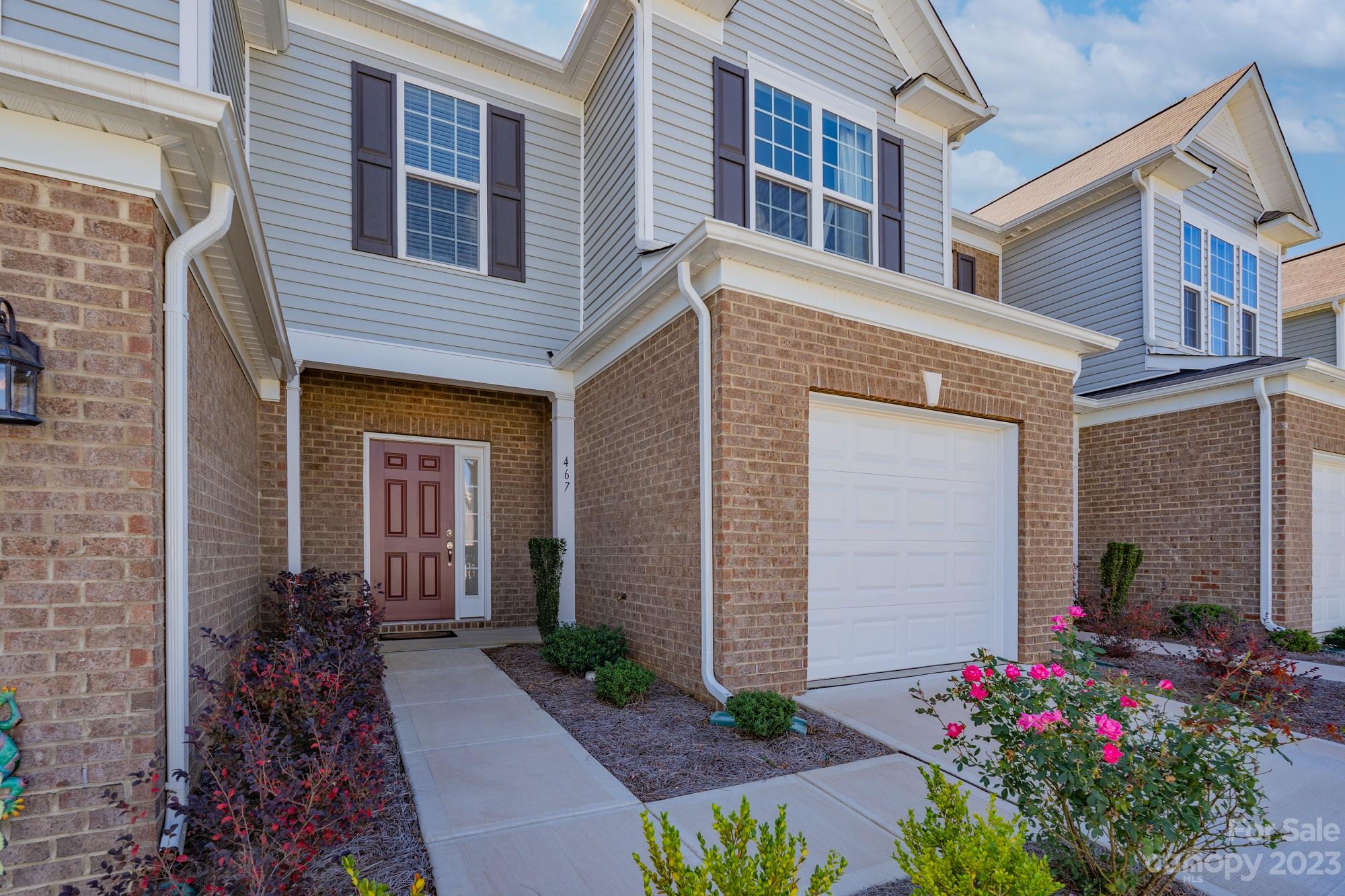 a front view of house and yard with flower pots