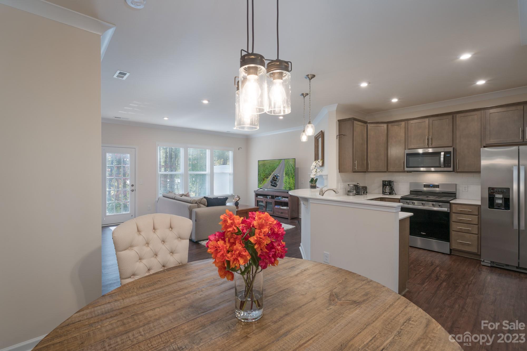 467 Hunters Dance Road Fort Mill, SC 29708 - Photo 2 of 28 a kitchen with stainless steel appliances granite countertop a kitchen island hardwood floor sink stove dining table and chairs