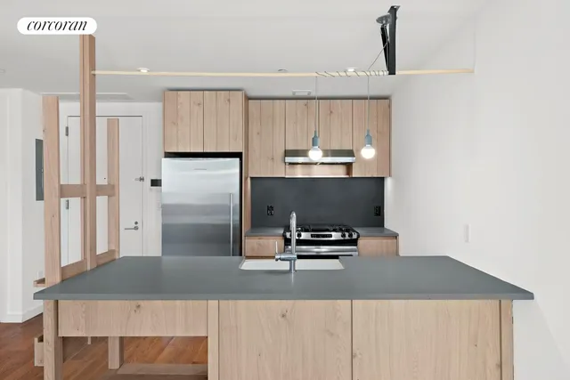 a kitchen with kitchen island a counter top a sink a stove and refrigerator