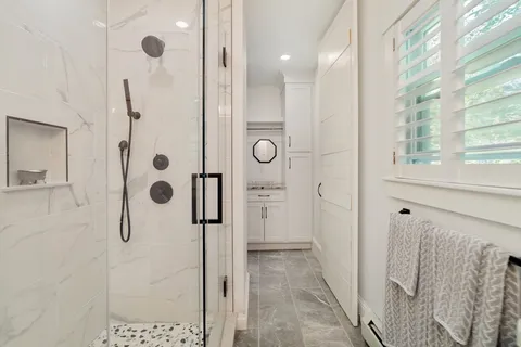 a bathroom with a shower and mirror
